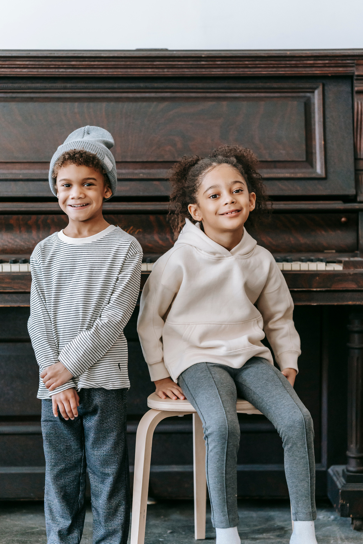 Young Siblings Posing by the Piano